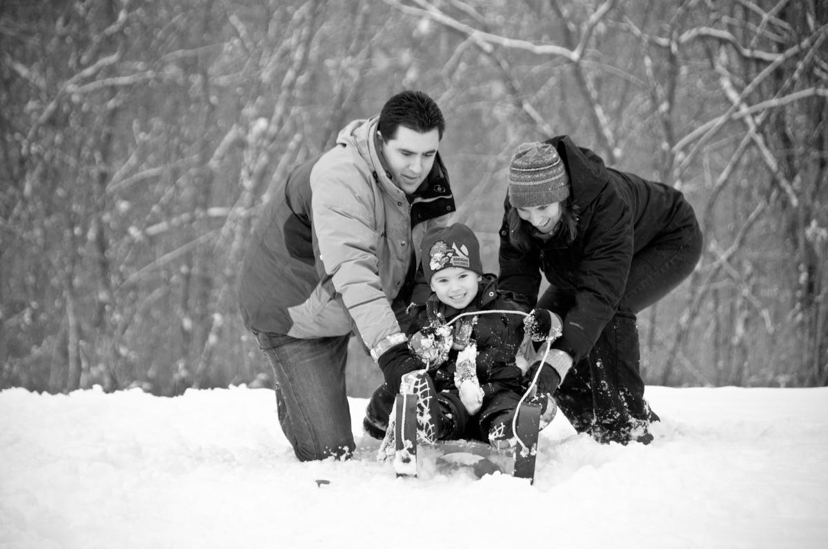 Black and white portrait of a family sledding