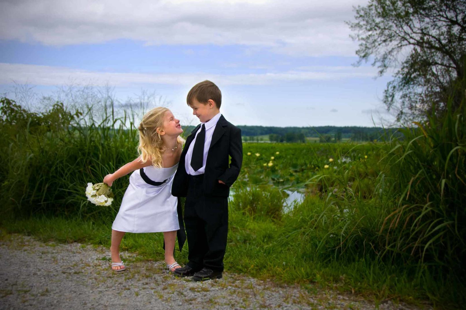 young boy and girl wearing formalwear looking at eachother.