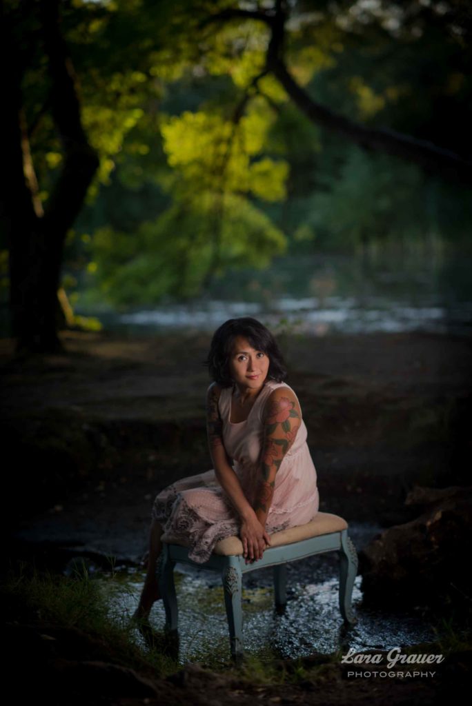 outdoor photo of a women sitting on a dressing stool with the lara grauer photography logo.