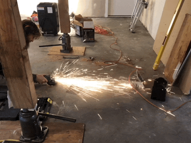 sparks flying off of a grinder used by a man working.