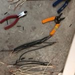pliers, tweezers, cable cutters, and many assortments of cut black and white wires.