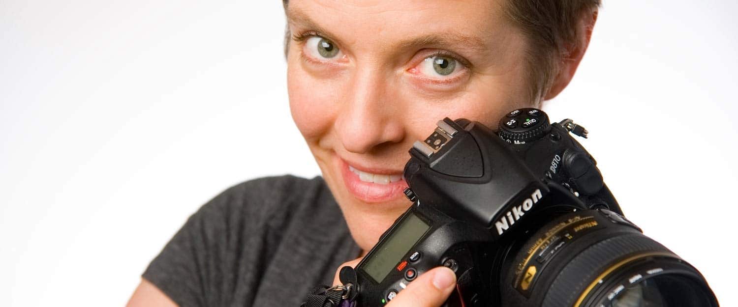 woman with dslr looking towards camera