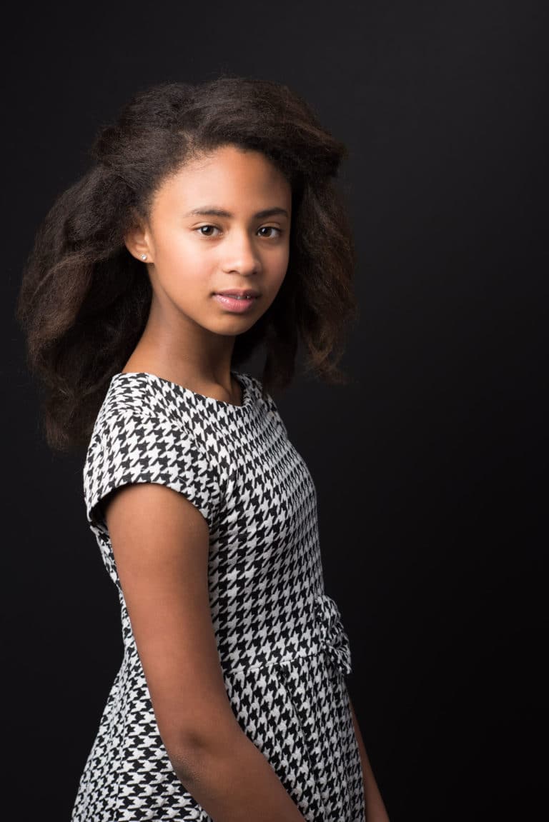 portrait of a young girl wearing a checkered dress