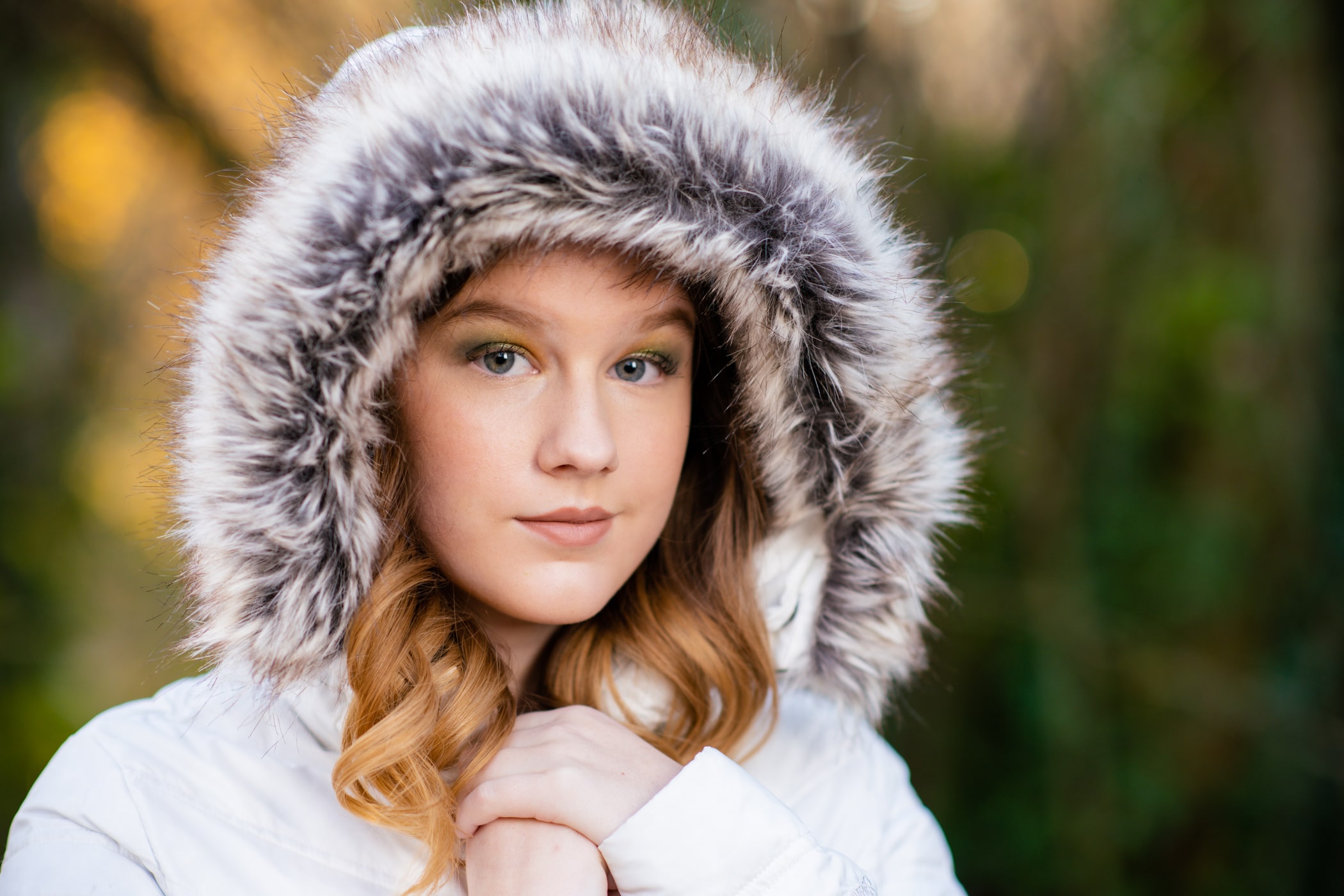 girl wearing white coat with furry hood around her face
