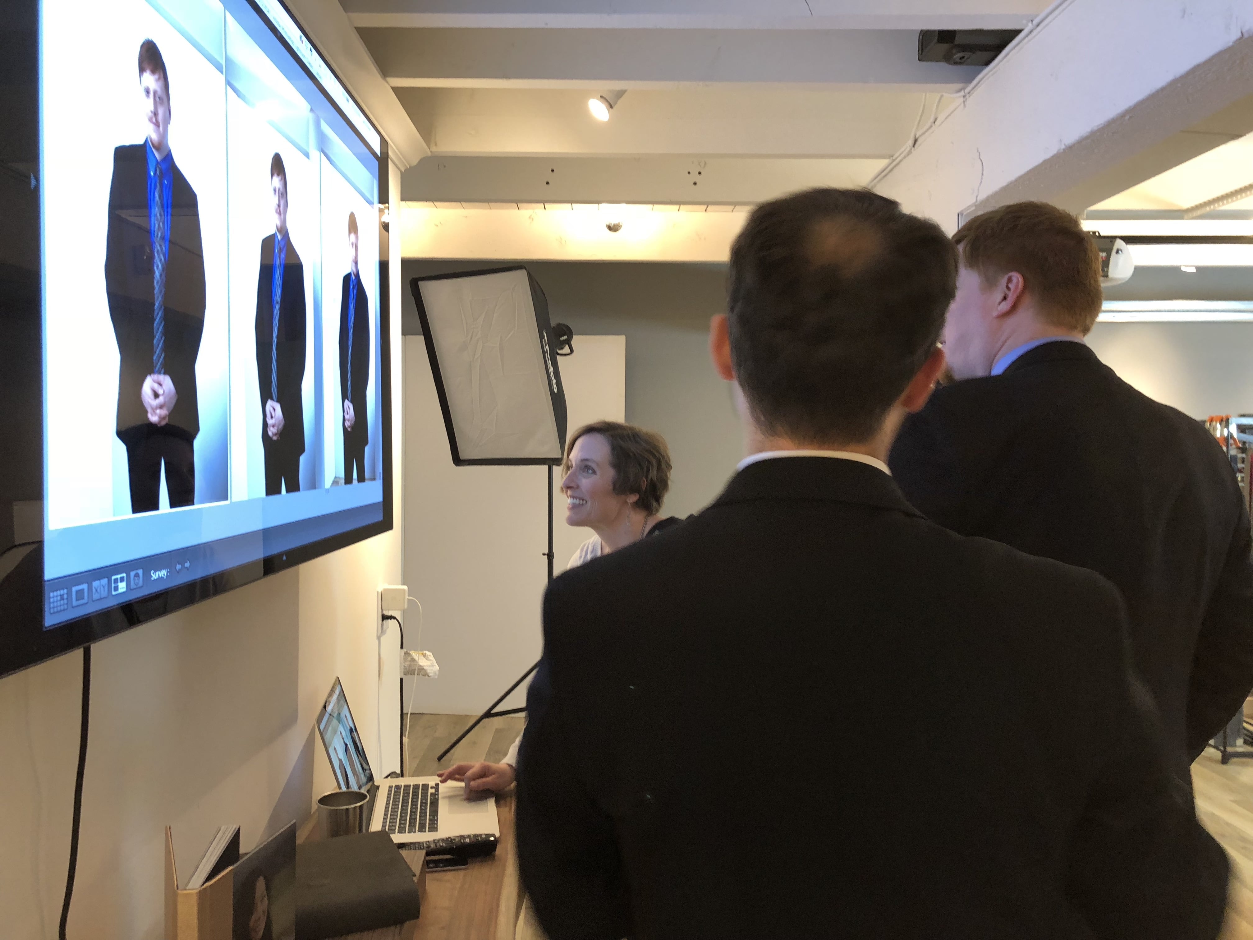Group of people looking at pictures on a big screen