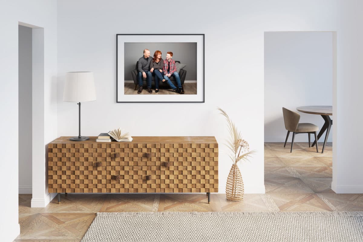 Portrait of a family hanging on a wall above a wooden dresser
