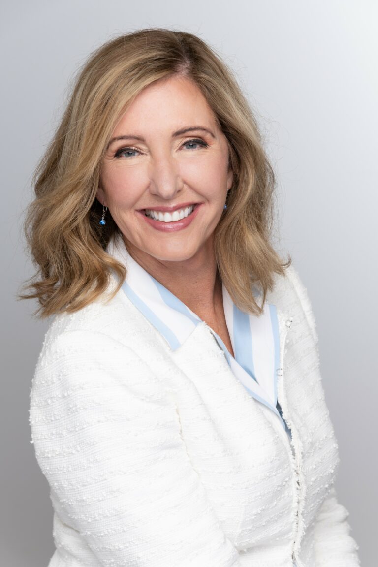 Headshot of a woman wearing a white zipper sweater.