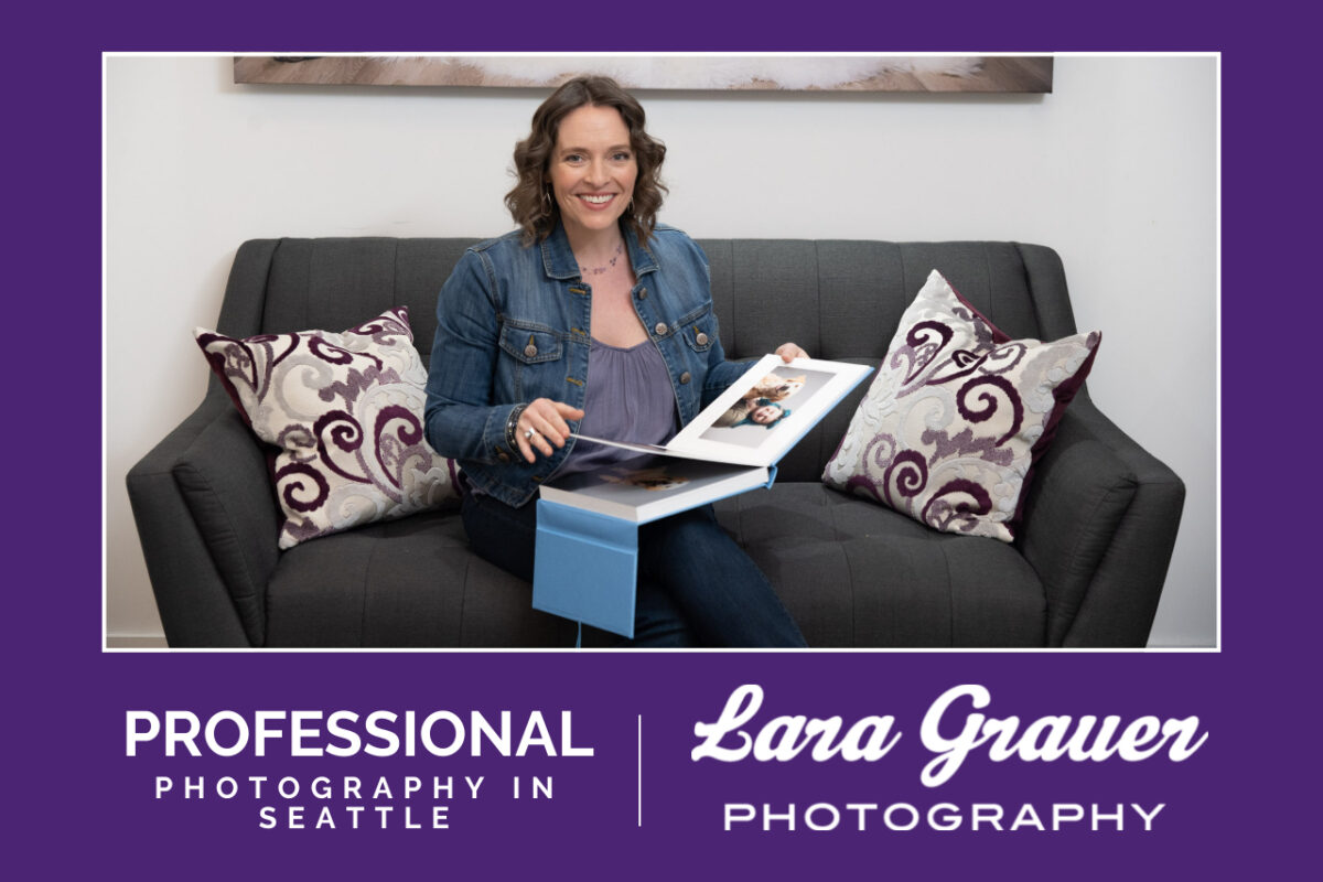 Woman sitting on couch holding a photo album