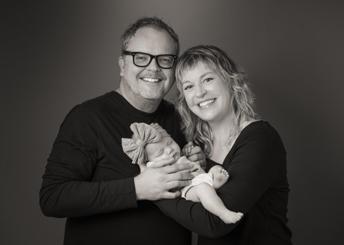 Erin, Justin, and baby Edith posing in our studio for a family portrait